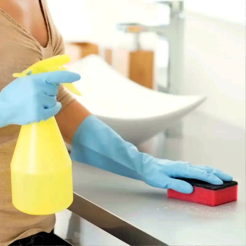Bathroom surface being cleaned with spray and sponge